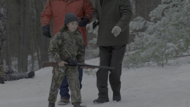 Wide shot frame from Daddy's Home 2 — standing, hat, gun