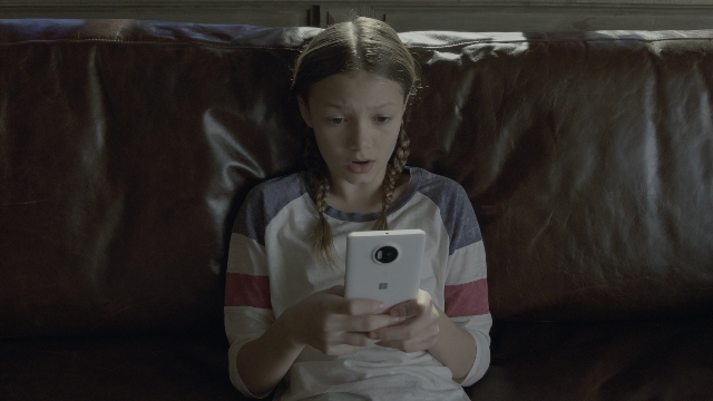 Wide shot frame from Daddy's Home 2 — sitting, phone, shirt