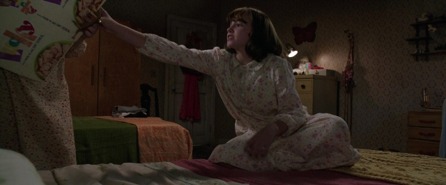 Wide shot frame from The Conjuring 2 — sitting, book, room