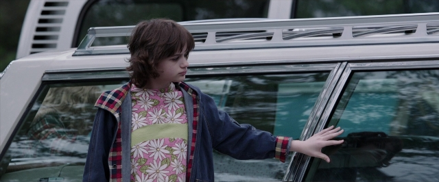 Wide shot frame from The Conjuring — standing, street, hand