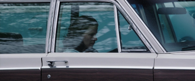 Wide shot frame from The Conjuring — door, street, car