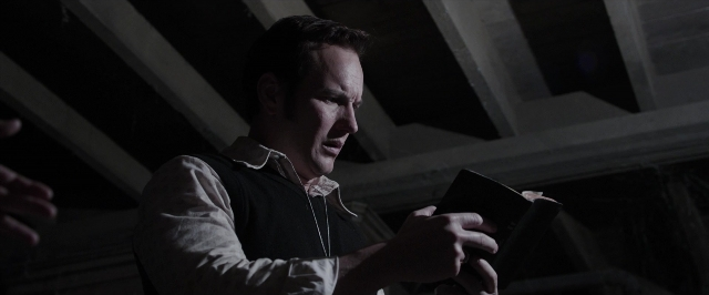 Wide shot frame from The Conjuring — book, standing, room