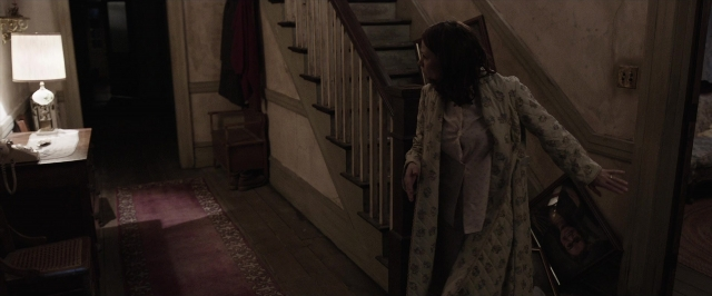 Wide shot frame from The Conjuring — standing, room, phone