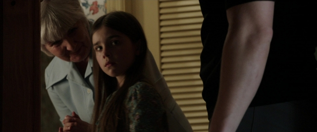 Wide shot frame from The Conjuring — standing, room, face