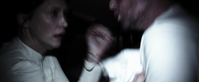 Wide shot frame from The Conjuring — room, dialogue, hand