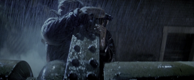 Wide shot frame from Blade Runner — standing, face, rain
