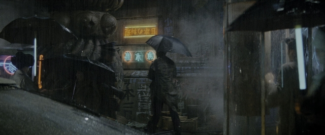 Medium shot frame from Blade Runner — standing, face, umbrella