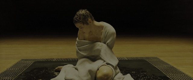 Wide shot frame from Blade Runner 2049 — sitting, person, human face