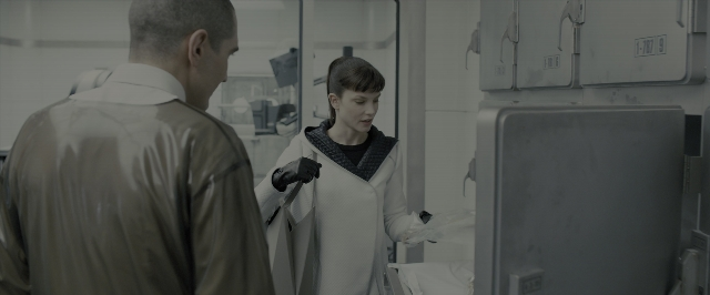 Wide shot frame from Blade Runner 2049 — standing, room, coat