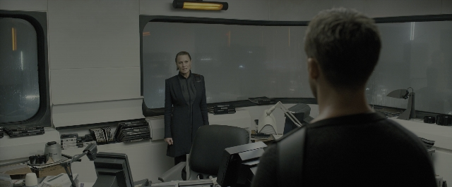 Wide shot frame from Blade Runner 2049 — standing, room, suit