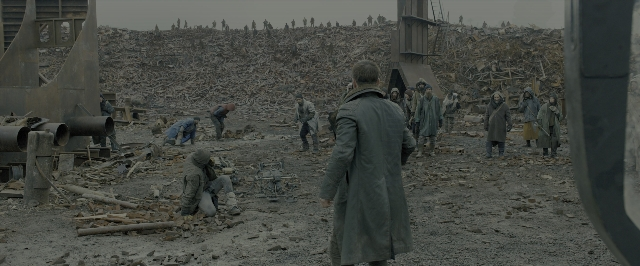 Wide shot frame from Blade Runner 2049 — standing, hat, coat