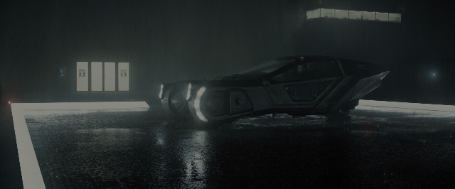 Wide shot frame from Blade Runner 2049 — room, car, wheel