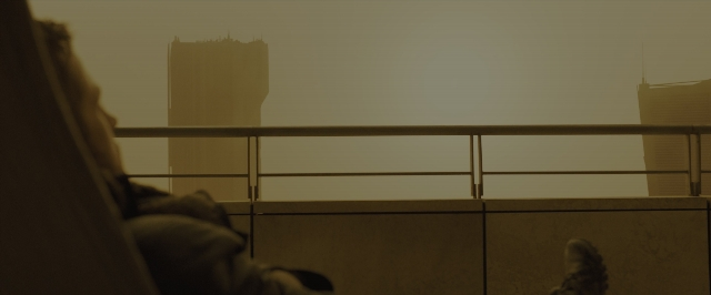 Frame from Blade Runner 2049 — sitting, skyscraper, smoke