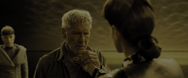 Wide shot frame from Blade Runner 2049 — standing, room, hand