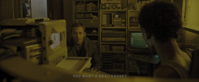 Wide shot frame from Blade Runner 2049 — sitting, room, face