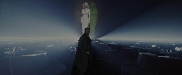 Wide shot frame from Blade Runner 2049 — standing, room, dress