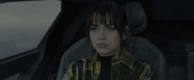 Medium shot frame from Blade Runner 2049 — sitting, car, shirt