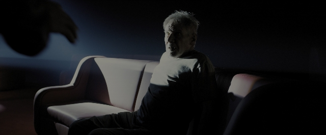 Wide shot frame from Blade Runner 2049 — sitting, room, shirt