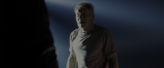 Wide shot frame from Blade Runner 2049 — standing, room, shirt