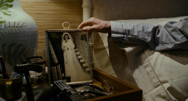 Wide shot frame from The Holiday — room, bed, hand