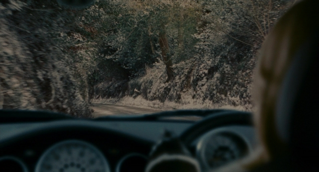 Wide shot frame from The Holiday — street, car, face
