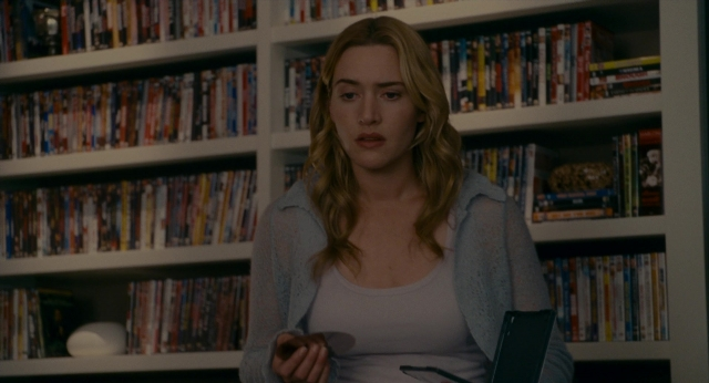 Wide shot frame from The Holiday — sitting, book, face