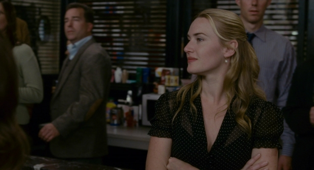 Wide shot frame from The Holiday — standing, room, suit