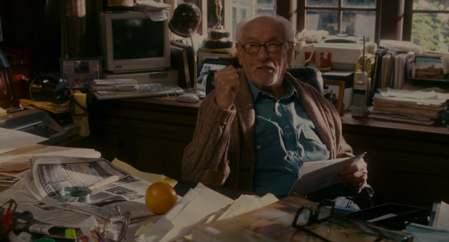 Wide shot frame from The Holiday — sitting, book, room