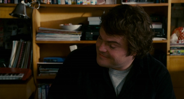 Wide shot frame from The Holiday — sitting, book, face