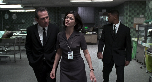 Medium shot frame from Men in Black — walking, room, suit