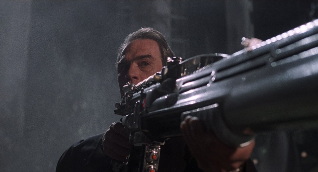 Frame from Men in Black — room, suit, gun