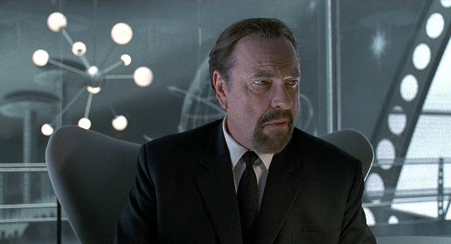 Medium shot frame from Men in Black — sitting, suit, tie