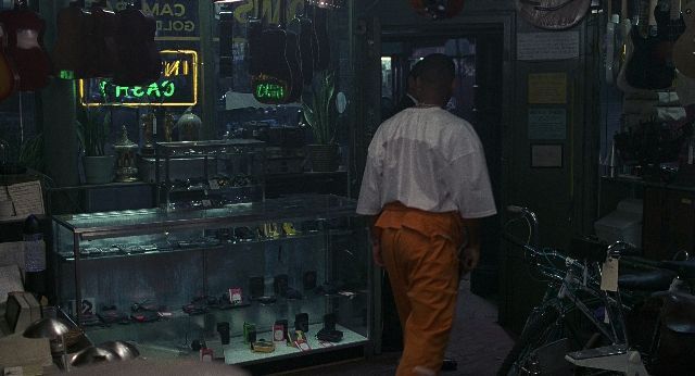 Wide shot frame from Men in Black — walking, bicycle, shirt
