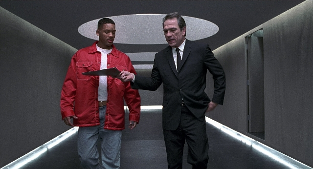 Wide shot frame from Men in Black — walking, hand, suit