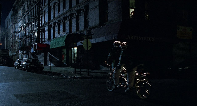 Wide shot frame from Men in Black — street, hat, car