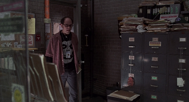 Wide shot frame from Men in Black — standing, room, shirt