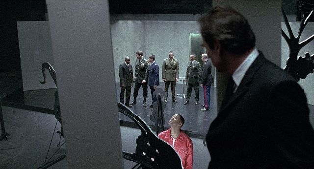 Wide shot frame from Men in Black — standing, room, suit