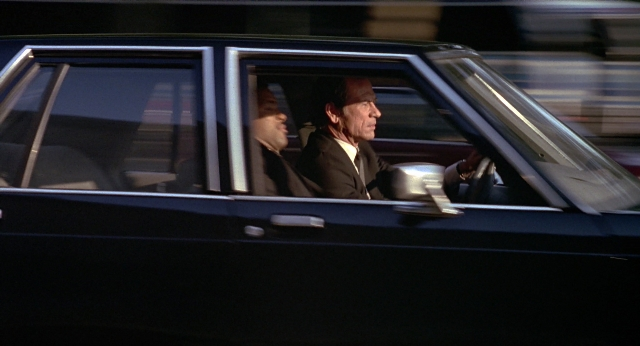 Wide shot frame from Men in Black — sitting, street, hat