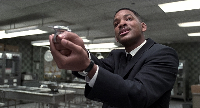 Wide shot frame from Men in Black — hand, suit, shirt