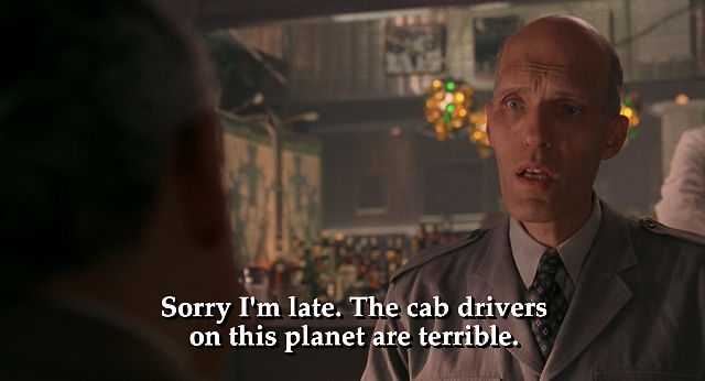 Medium shot frame from Men in Black — standing, room, suit