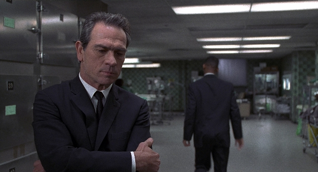 Wide shot frame from Men in Black — standing, walking, suit