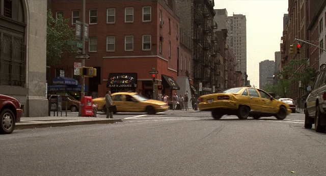 Wide shot frame from Men in Black — walking, street, car