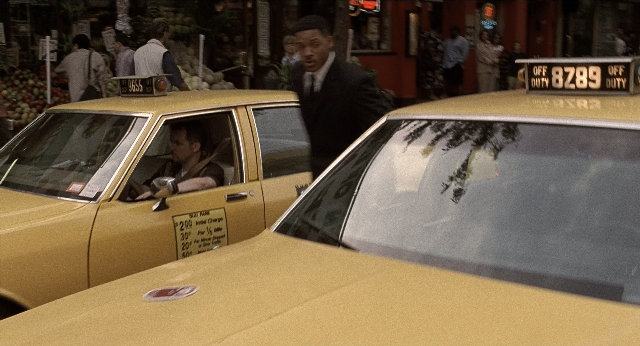 Wide shot frame from Men in Black — standing, walking, street