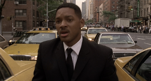 Medium shot frame from Men in Black — standing, walking, street