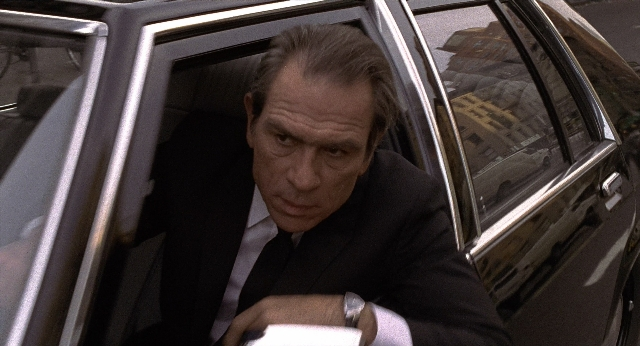 Medium shot frame from Men in Black — sitting, street, car