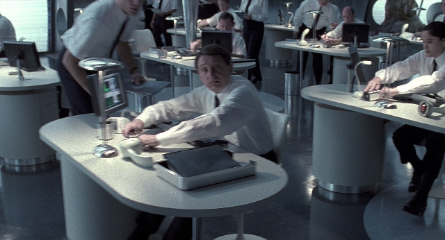 Wide shot frame from Men in Black — sitting, standing, room