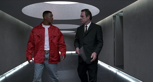 Wide shot frame from Men in Black — walking, hand, suit