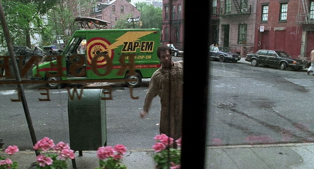Wide shot frame from Men in Black — walking, street, car