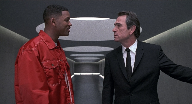 Wide shot frame from Men in Black — standing, room, dialogue