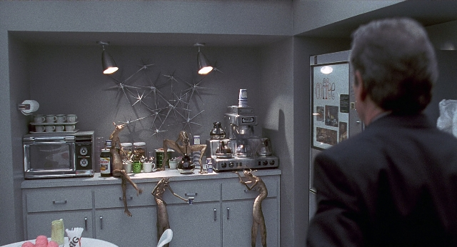 Wide shot frame from Men in Black — standing, plate, table